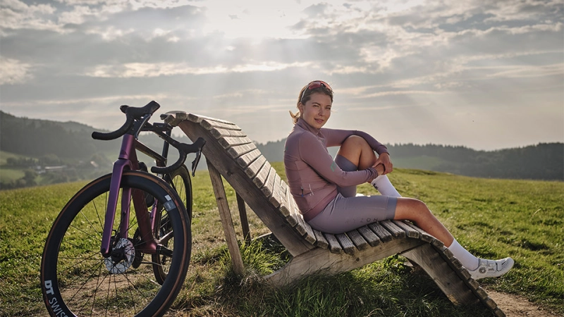 JobRad-Rennradlerin sitzt auf einer Bank und genießt die Aussicht JobRad-Rennradlerin sitzt auf einer Bank und genießt die Aussicht